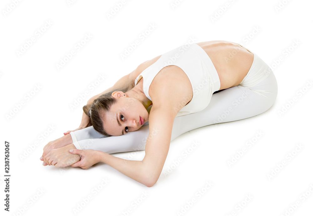 A young woman in a white suit performs acrobatic elements and yoga. A young woman in a white suit performs acrobatic elements and yoga.