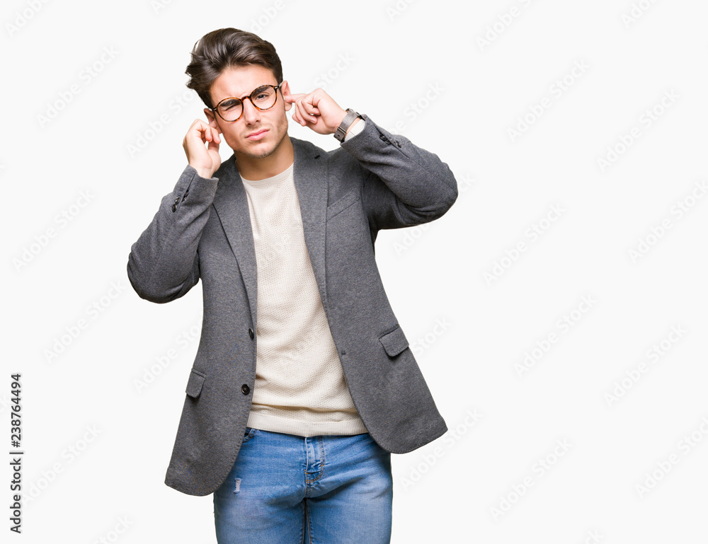 Young business man wearing glasses over isolated background covering ears with fingers with annoyed expression for the noise of loud music. Deaf concept. Young business man wearing glasses over isolated background covering ears with fingers with annoyed expression for the noise of loud music. Deaf concept.