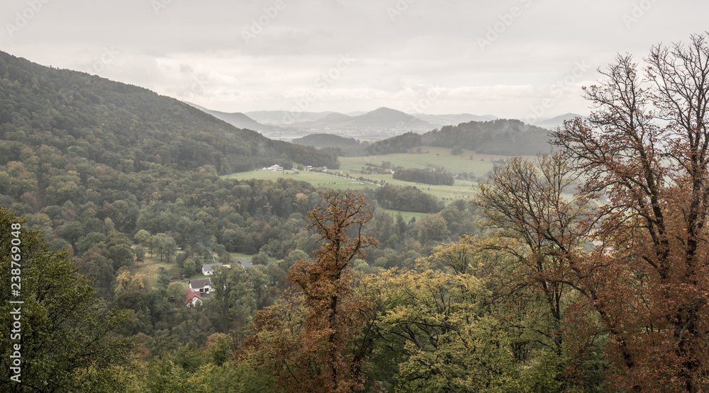 Fototapeta premium autumn landscape with smaller hills, forest, meadows and isolated group of houses