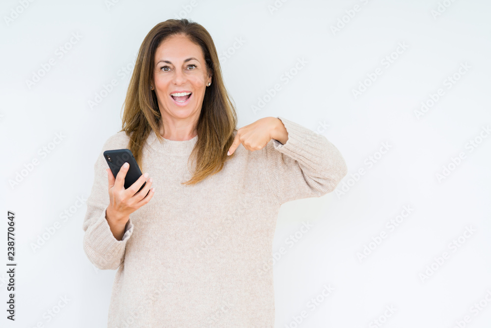 Middle age woman using smartphone over isolated background with surprise face pointing finger to himself Middle age woman using smartphone over isolated background with surprise face pointing finger to himself