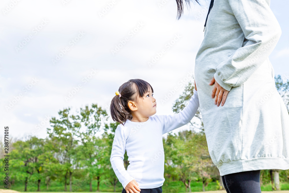 妊娠したお母さんの大きなお腹を触る幼い女の子 妊娠 妊婦 親子 家族 愛 幸せイメージ Stock 写真 Adobe Stock