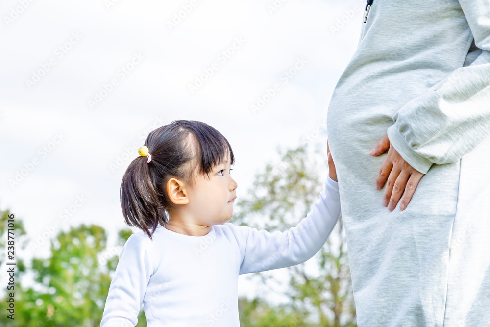 妊娠したお母さんの大きなお腹を触る幼い女の子 妊娠 妊婦 親子 家族 愛 幸せイメージ Stock Foto Adobe Stock