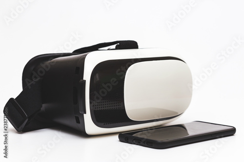 Close up view of a VR - VIRTUAL REALITY GLASSES and a SMART PHONE over white background