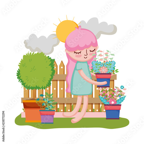 girl lifting houseplant with fence in the garden