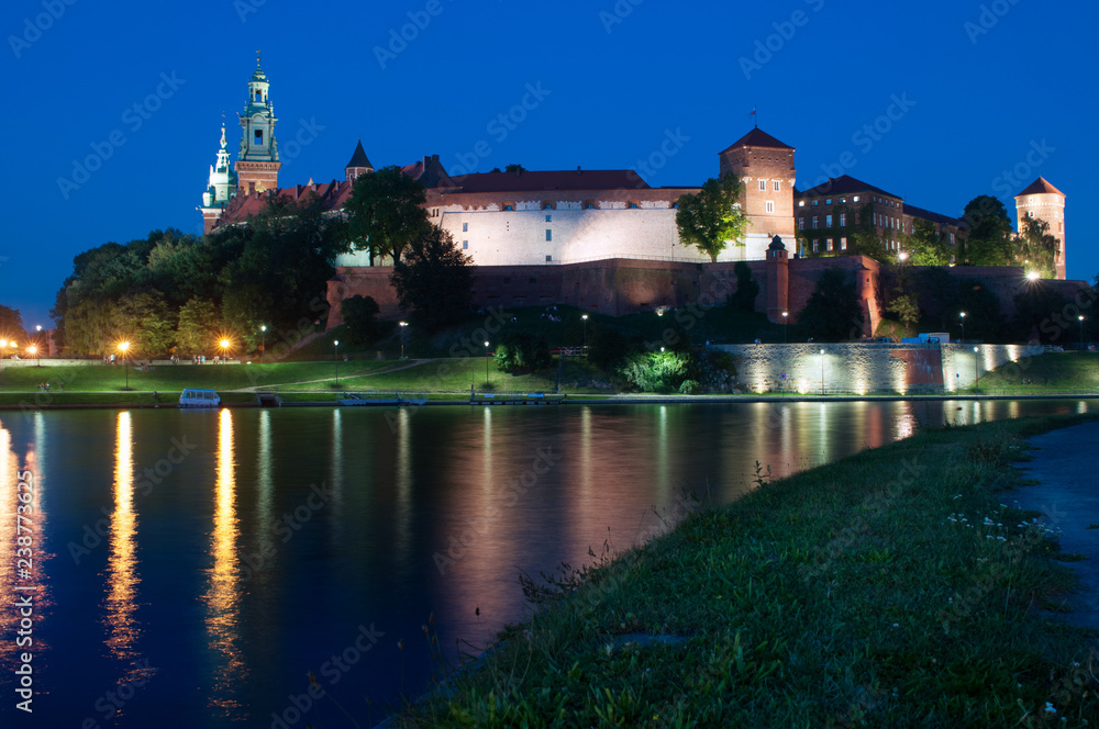 Castle Wawel - a hill and an architectural complex in Krakow, Poland,  on the left bank of the Vistula. Castle Wawel in the evening light, view from the bridge.