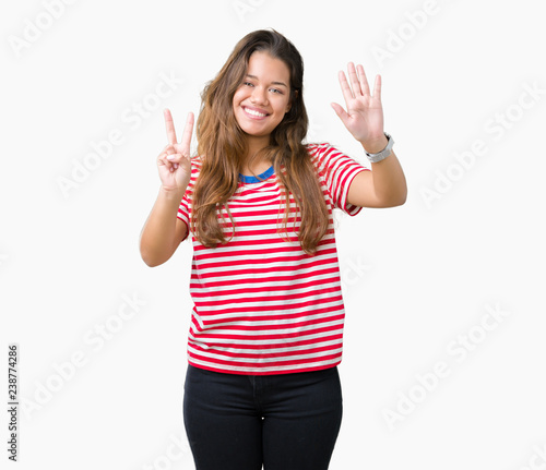 Young beautiful brunette woman wearing stripes t-shirt over isolated background showing and pointing up with fingers number seven while smiling confident and happy.