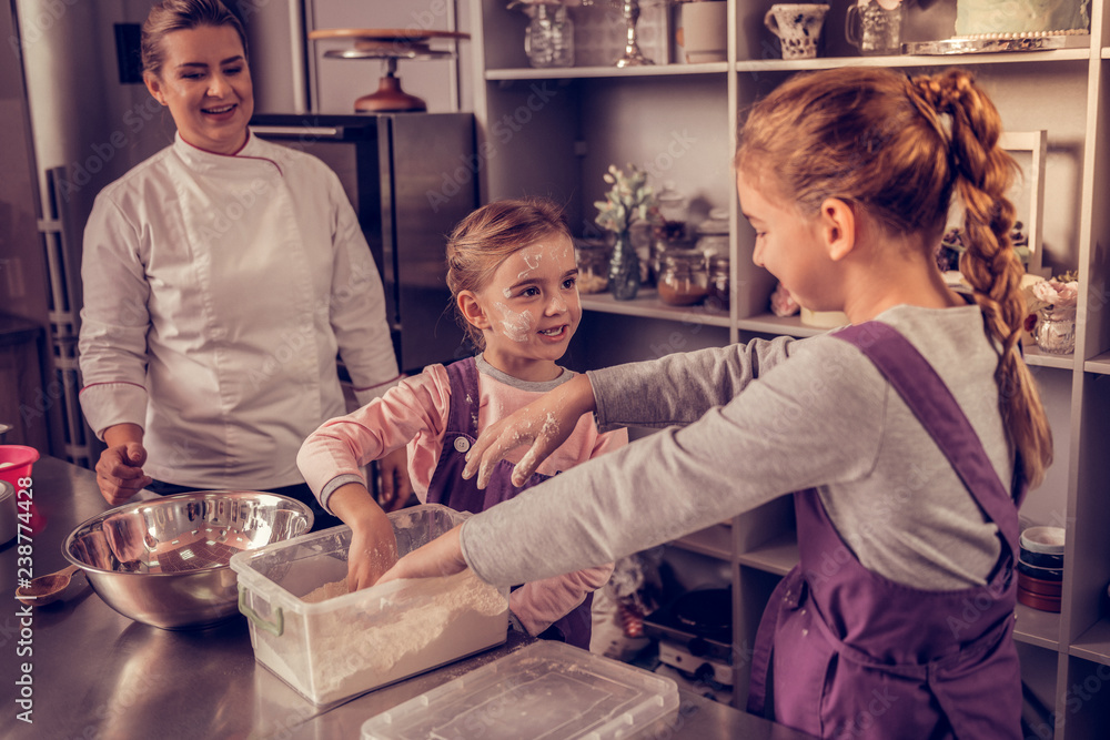 Obraz premium Positive nice girl looking at her sister