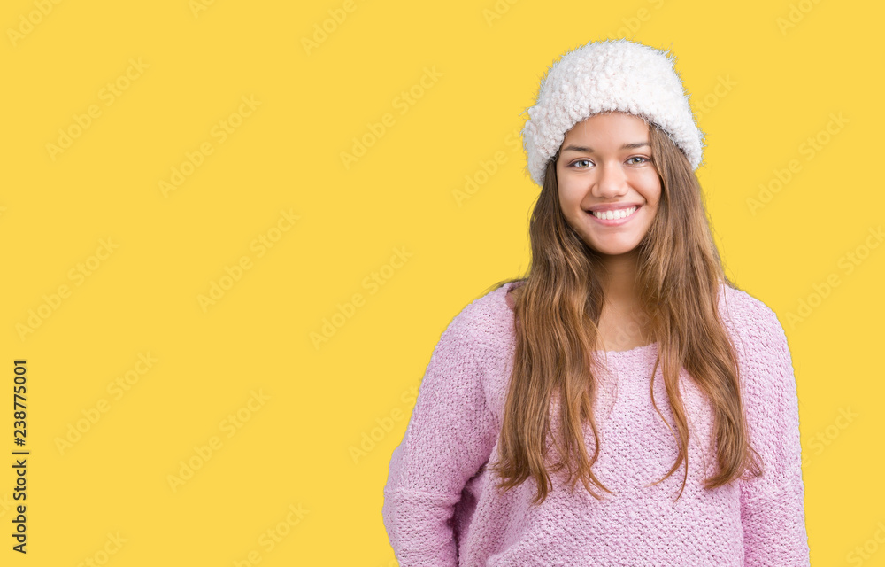 Young beautiful brunette woman wearing sweater and winter hat over isolated background with a happy and cool smile on face. Lucky person. Young beautiful brunette woman wearing sweater and winter hat over isolated background with a happy and cool smile on face. Lucky person.