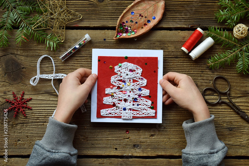 Making of handmade christmas greeting card from felt with your own hands. Children's DIY concept. Making xmas decoration