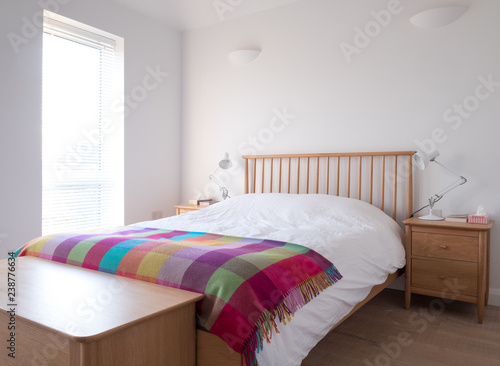 Принти на полотні Scandinavian inspired, minimalist bedroom interior showing wooden bedroom furniture, white painted walls, white bedding and colourful blanket