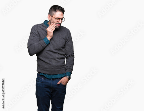 Young handsome man wearing glasses over isolated background touching mouth with hand with painful expression because of toothache or dental illness on teeth. Dentist concept.