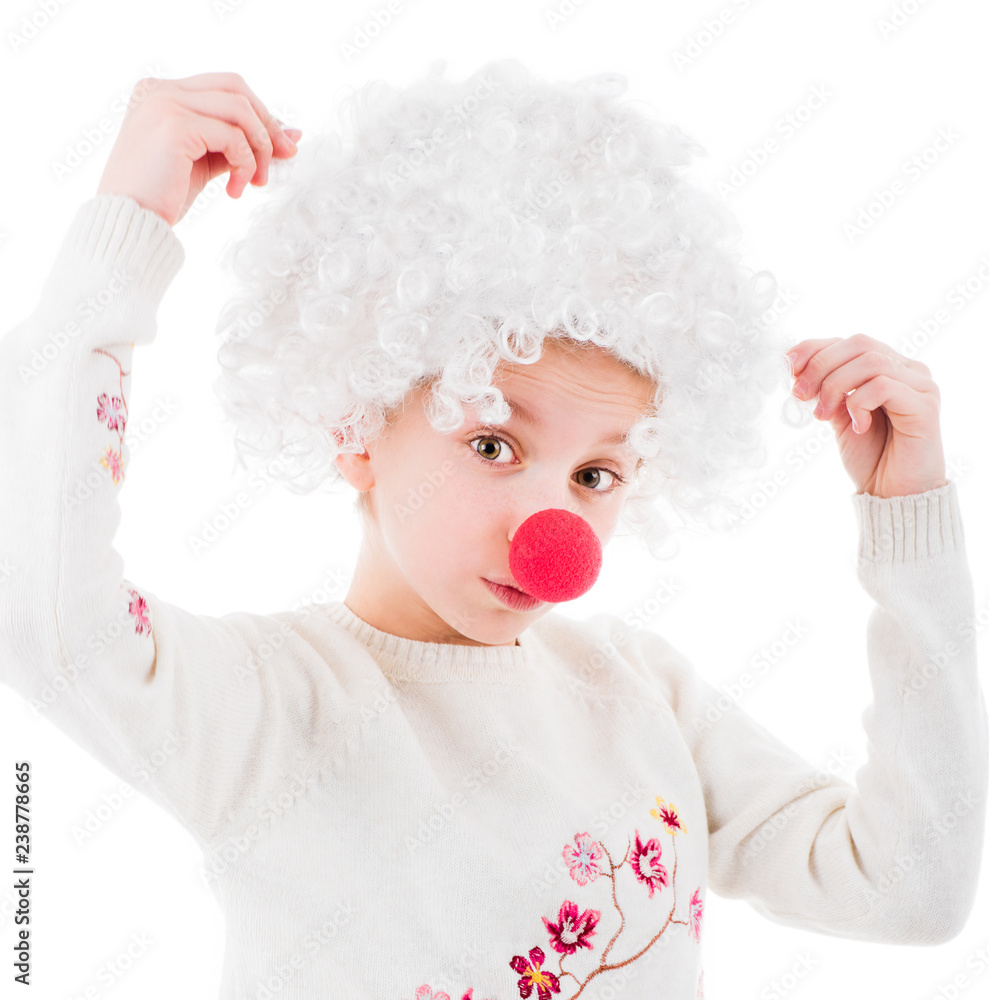 Lovely little girl in white voluminous clown wig and red nose posing in front of camera isolated on white background