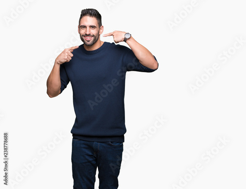 Young handsome man wearing sweater over isolated background smiling confident showing and pointing with fingers teeth and mouth. Health concept.
