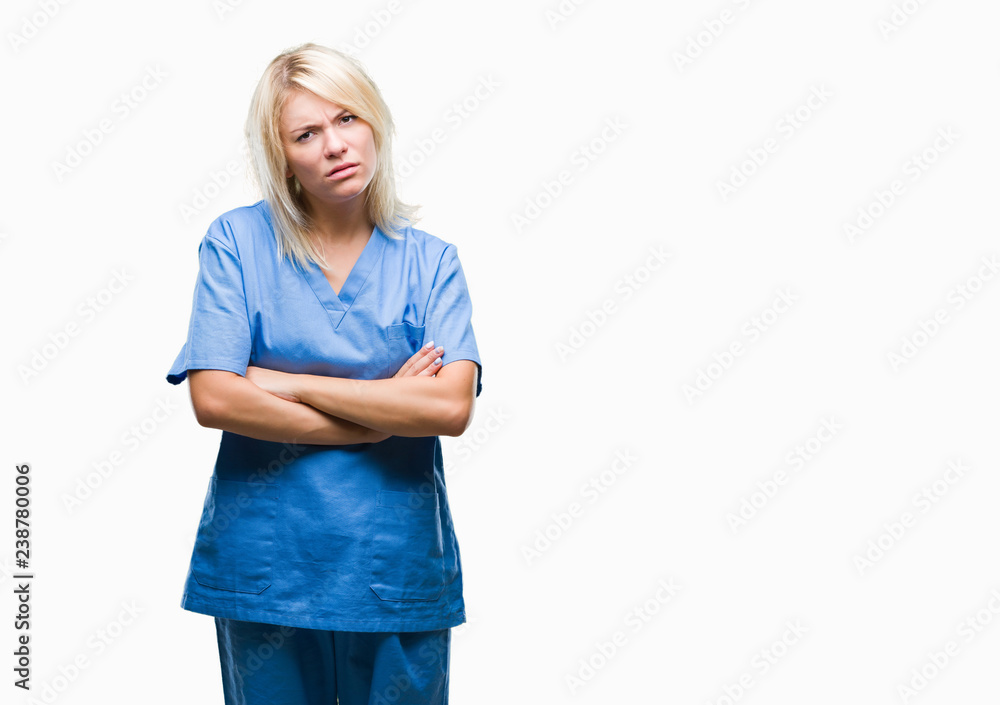 Young beautiful blonde nurse doctor woman over isolated background skeptic and nervous, disapproving expression on face with crossed arms. Negative person. Young beautiful blonde nurse doctor woman over isolated background skeptic and nervous, disapproving expression on face with crossed arms. Negative person.
