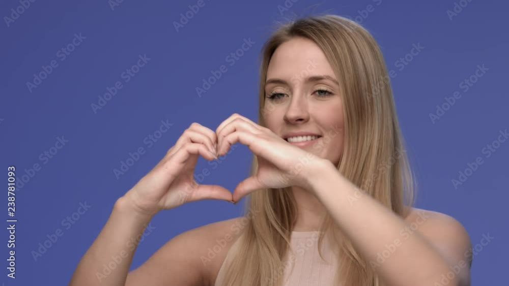 Attractive and young woman forming a heart with her hands Attractive and young woman forming a heart with her hands