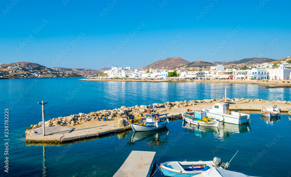 Motorboats and fishing boats anchored in harbour near the beach at sunny weather, Paros, Greece