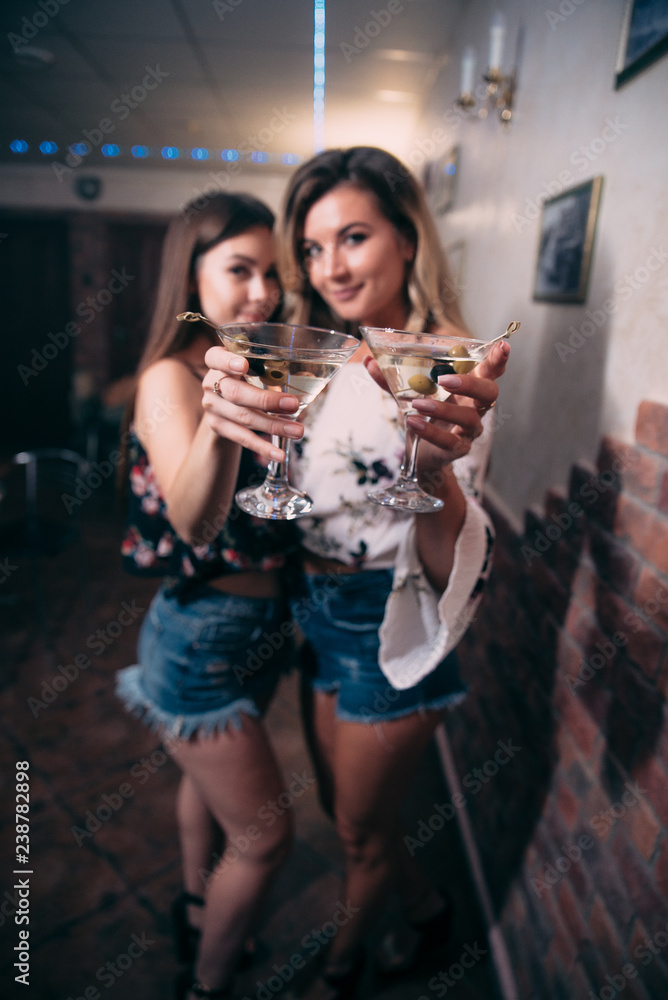 Girls with glasses of white wine in a nightclub