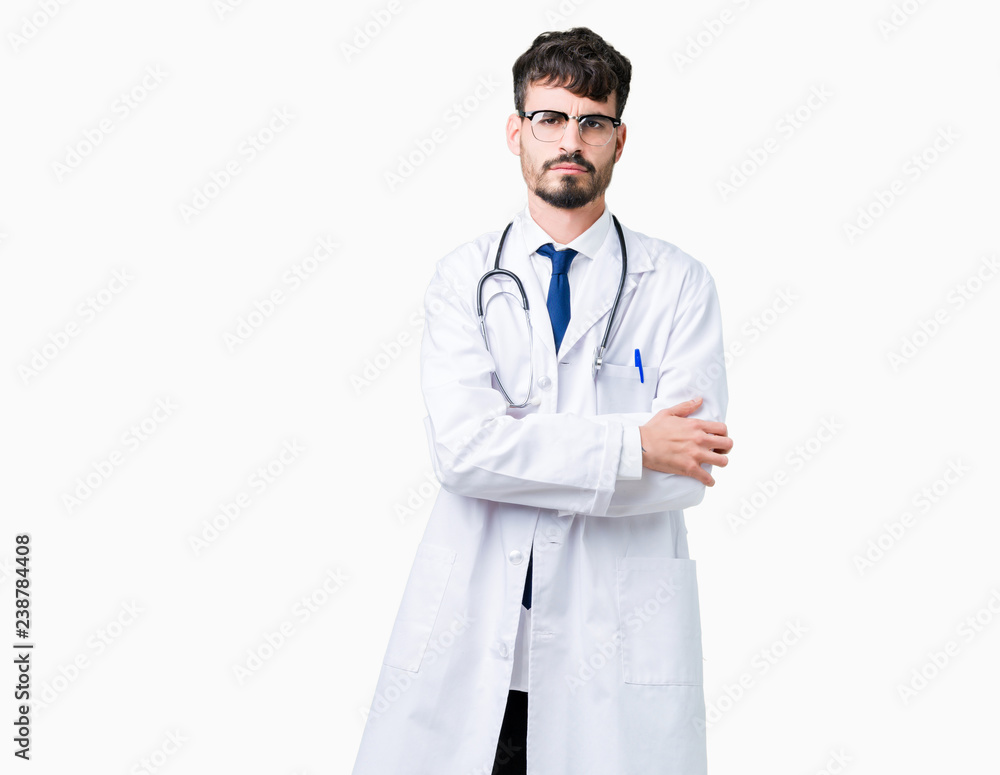 Young doctor man wearing hospital coat over isolated background skeptic and nervous, disapproving expression on face with crossed arms. Negative person. Young doctor man wearing hospital coat over isolated background skeptic and nervous, disapproving expression on face with crossed arms. Negative person.