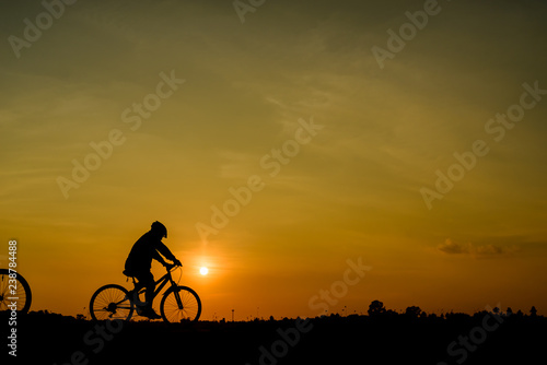 silhouette of cyclist at sunset