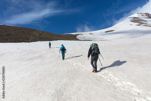 The tourists rises up the mountainside to the snow-capped summit