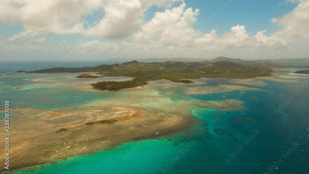 Aerial view: beach, tropical island, sea bay and lagoon, Siargao. Tropical landscape hill, clouds and mountains rocks with rainforest. Azure water of lagoon. Shore Landscape Bay. Aerial video.Seascape