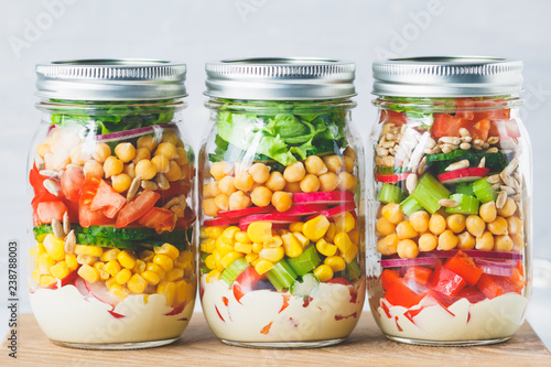 Fotografie Glass jars with layering various vegan salads for healthy lunch