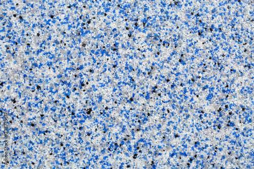 Close up of decorative quartz sand epoxy floor or wall coating with blue, grey, white and black coloured particles