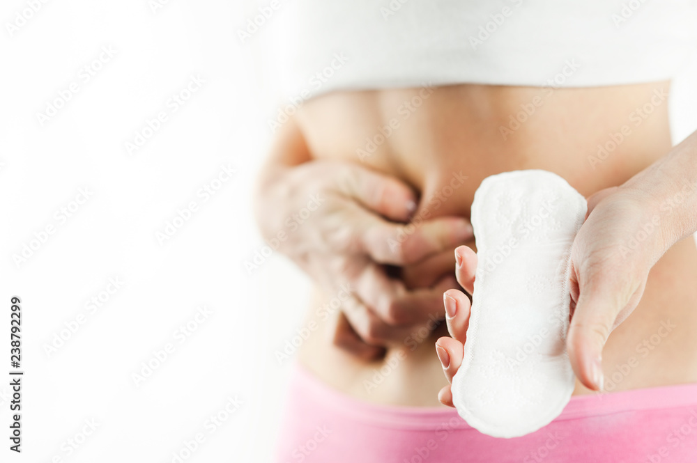 Fototapeta premium Women Period Product. Closeup Of Beautiful Fit Slim Female Body In White Underwear Holding Sanitary Napkin, Towel In Hand. Woman Holding Clean Period Pad. Feminine Intimate Hygiene. High Resolution
