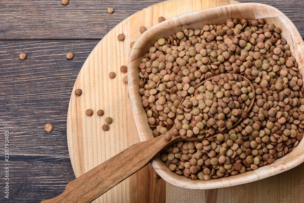 A wooden spoon full of canadian green large lentils A wooden spoon full of canadian green large lentils