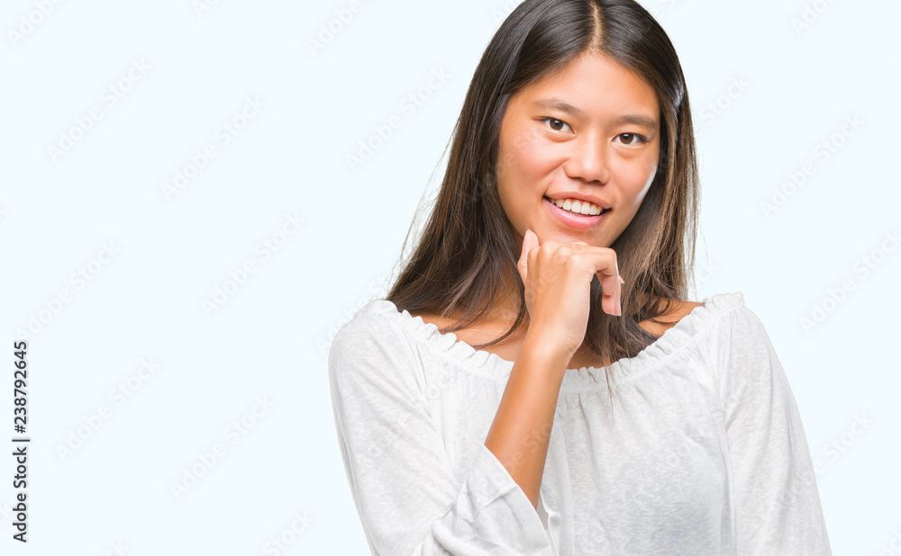 Young asian woman over isolated background looking confident at the camera with smile with crossed arms and hand raised on chin. Thinking positive.