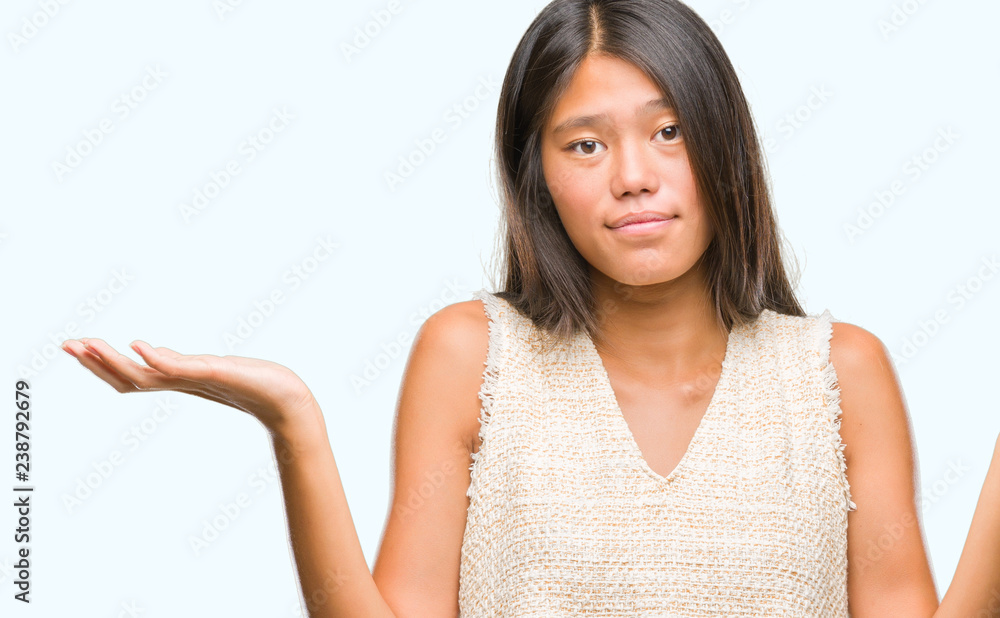 Young asian woman over isolated background clueless and confused expression with arms and hands raised. Doubt concept. Young asian woman over isolated background clueless and confused expression with arms and hands raised. Doubt concept.