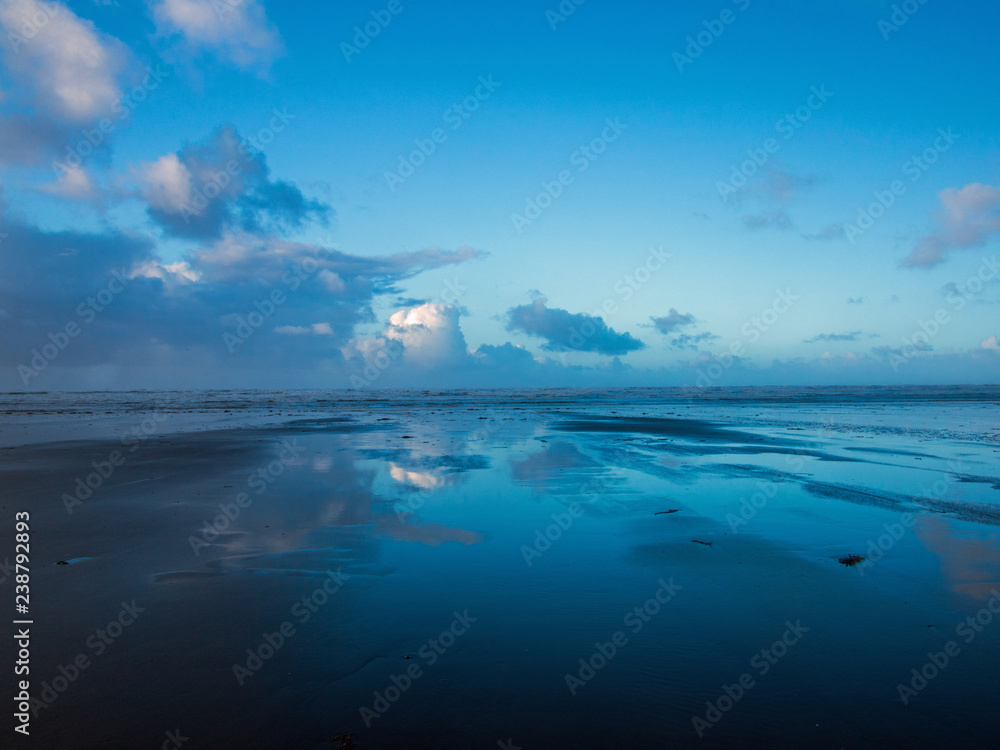 Fototapeta nastrojowe błękitne niebo i odbicia chmur na Westward Ho! plaża w Devon w Anglii?