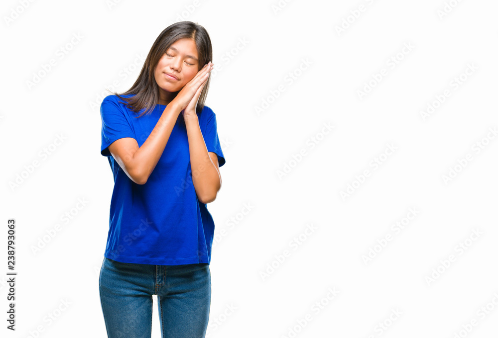 Young asian woman over isolated background sleeping tired dreaming and posing with hands together while smiling with closed eyes. Young asian woman over isolated background sleeping tired dreaming and posing with hands together while smiling with closed eyes.