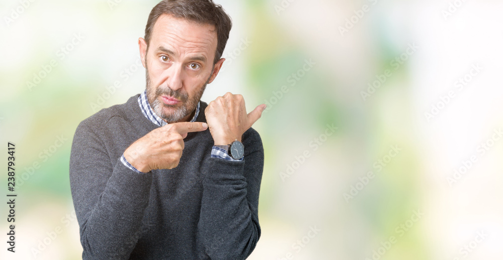 Handsome middle age senior man wearing a sweater over isolated background In hurry pointing to watch time, impatience, upset and angry for deadline delay Handsome middle age senior man wearing a sweater over isolated background In hurry pointing to watch time, impatience, upset and angry for deadline delay
