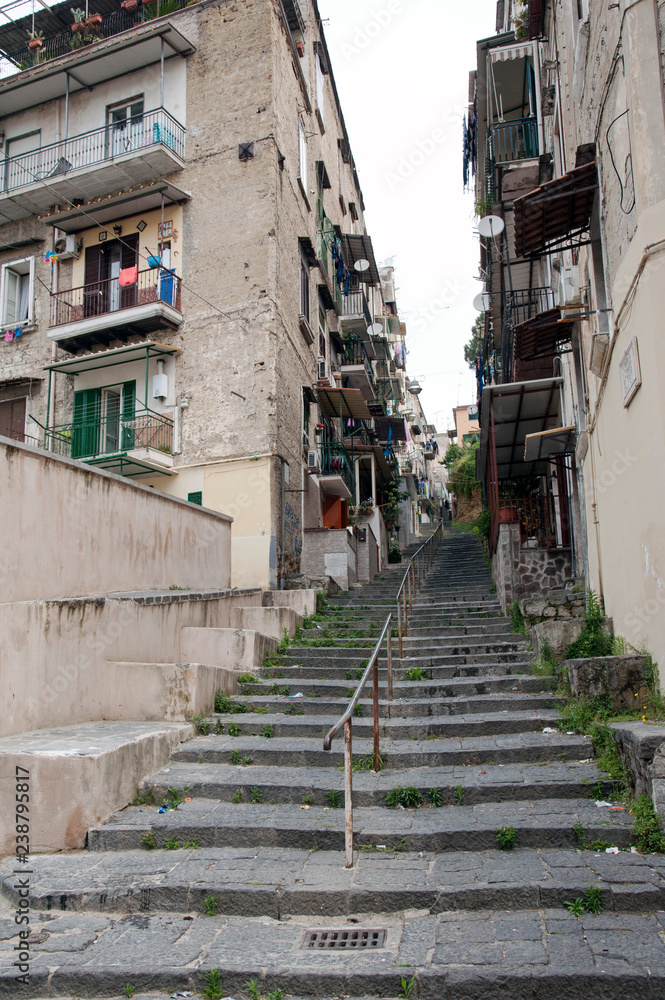 Alley with staircase paved with lava stones in the populated suburb called 