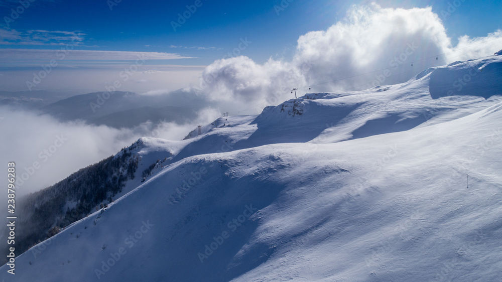 Winter landscape. Slope on the skiing resort in Carpathians. Freeride snowboarding. Ski. Winter Sports. Olympics. Aerial View. Ski Lift in the mountains. Cable car on the ski resort in the winter. 