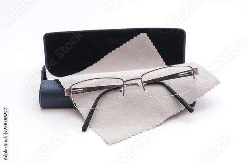 Glasses and case with glasses cleaning cloth on white background