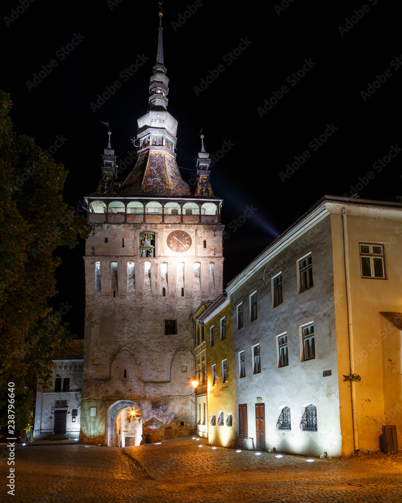 Night scene with the tower clock of the medieval town of Sighisoara, in Romania