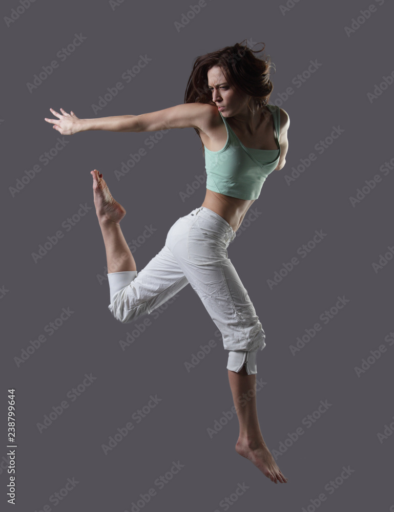 Woman jump. Beauty girl dance on grey background Woman jump. Beauty girl dance on grey background