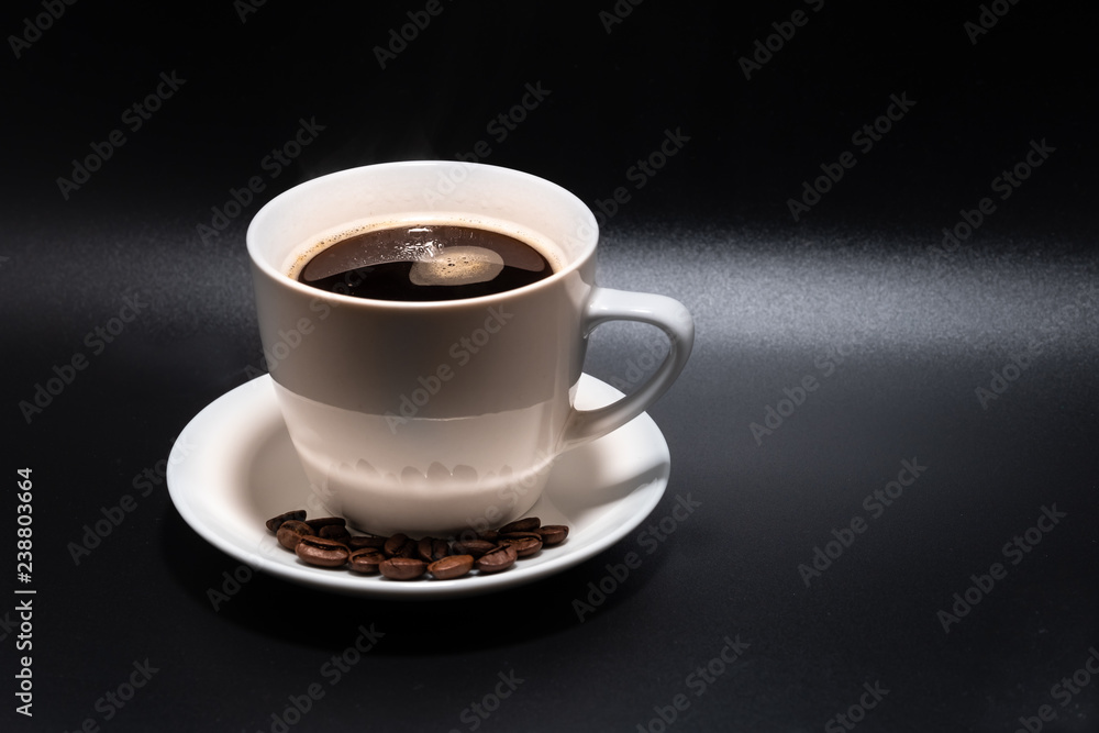 White cup and saucer with coffee on a black background White cup and saucer with coffee on a black background