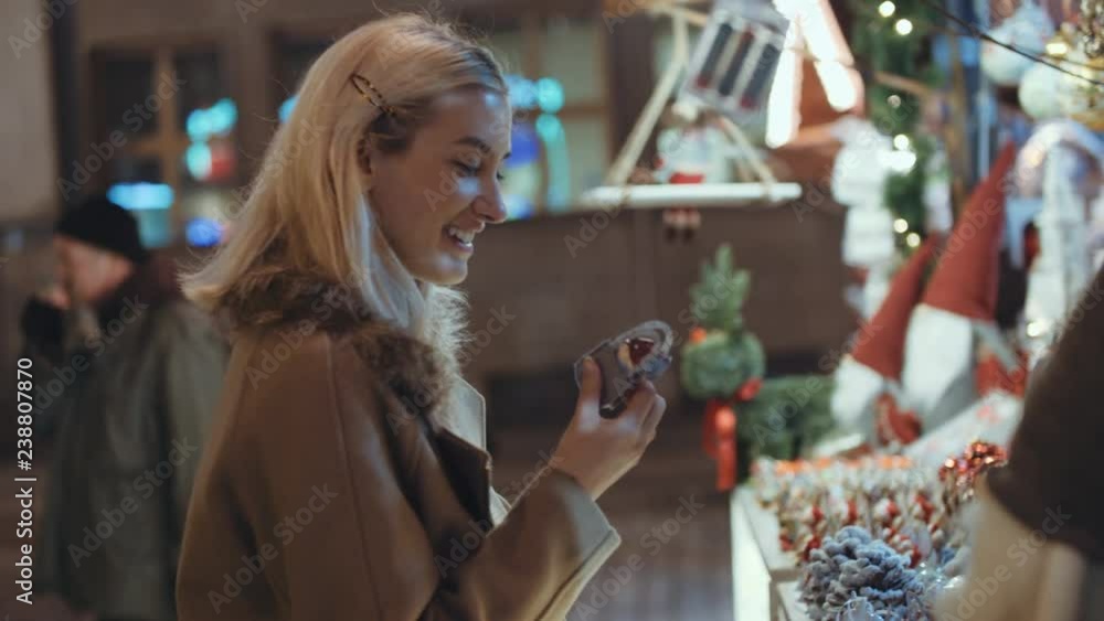 Young blonde girl having fun at christmas market in a city. Happy attractive woman in a christmas market at night. Beautiful bokeh lights background. Young blonde girl having fun at christmas market in a city. Happy attractive woman in a christmas market at night. Beautiful bokeh lights background.