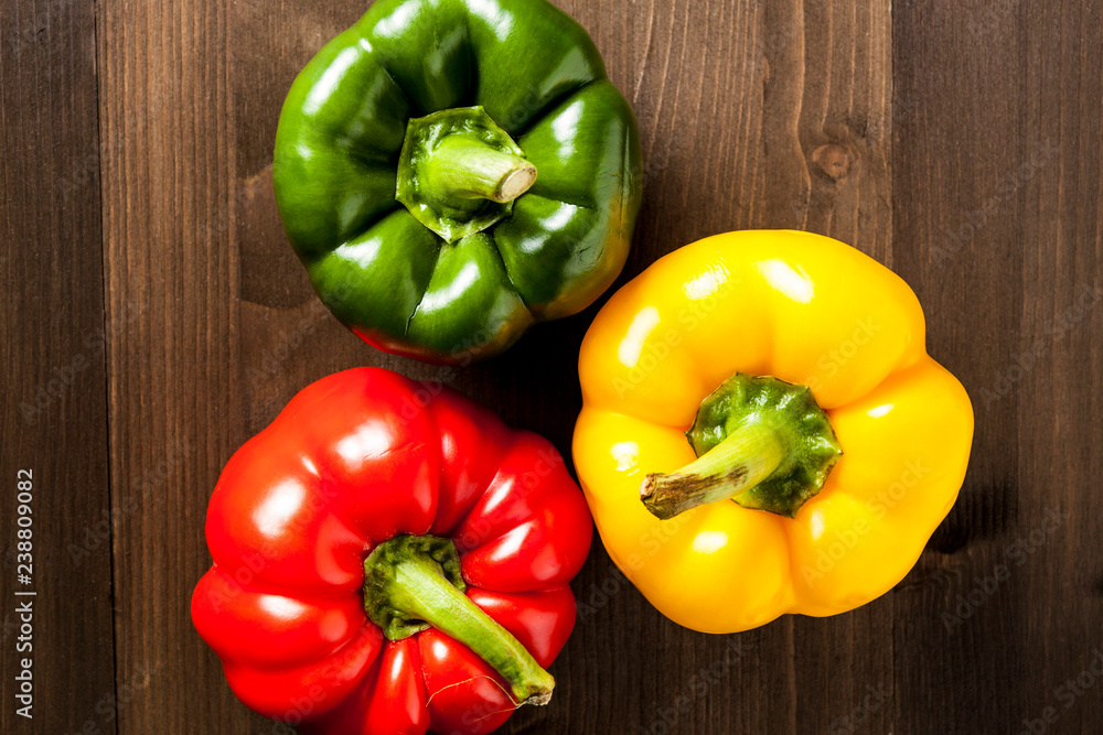 Fresh bell peppers isolated on wooden cutting board Fresh bell peppers isolated on wooden cutting board