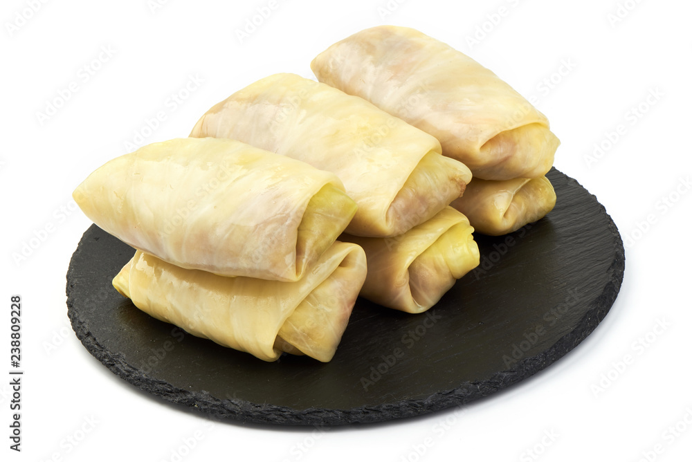 Stuffed cabbage leaves with meat on a slate shale plate, isolated on a white background. Close-up Stuffed cabbage leaves with meat on a slate shale plate, isolated on a white background. Close-up