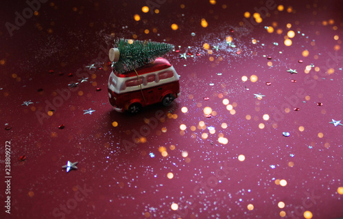 Toy red car with fir tree on the roof.