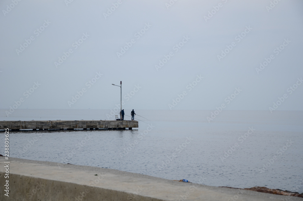 Three Fishermans are standing on seashore. Three Fishermans are standing on seashore.