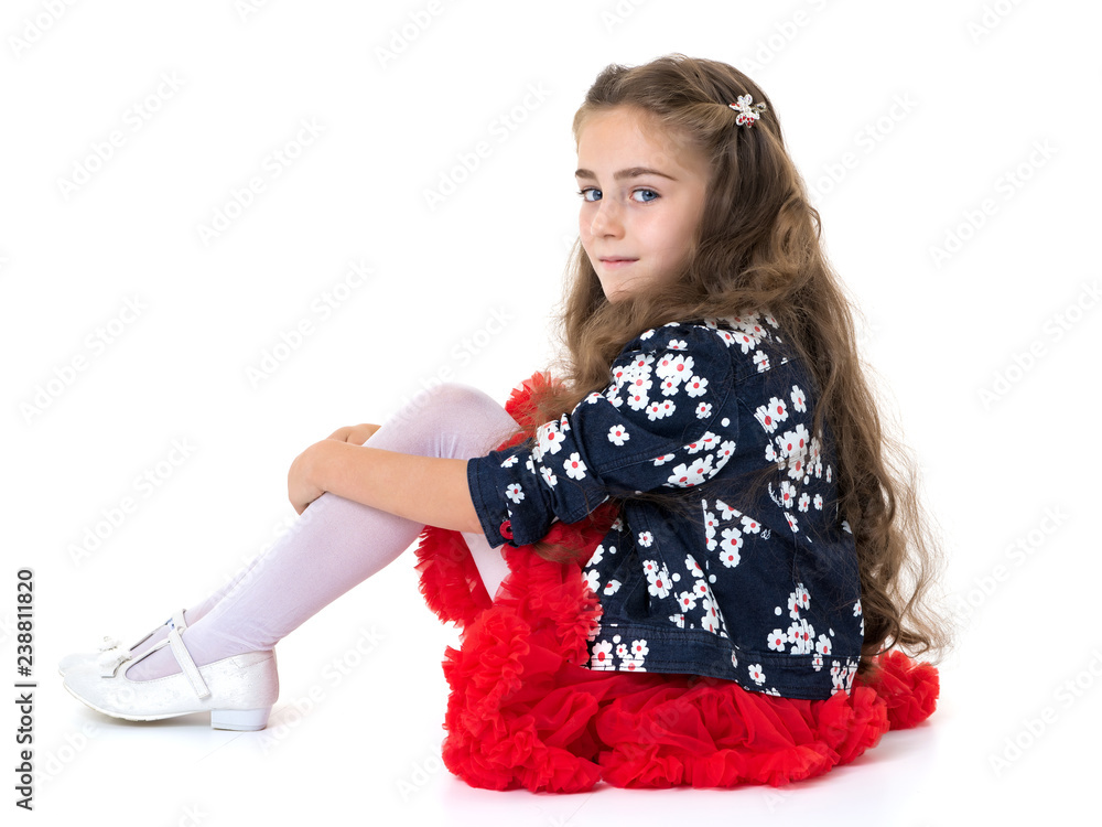 Little girl is sitting on the floor.