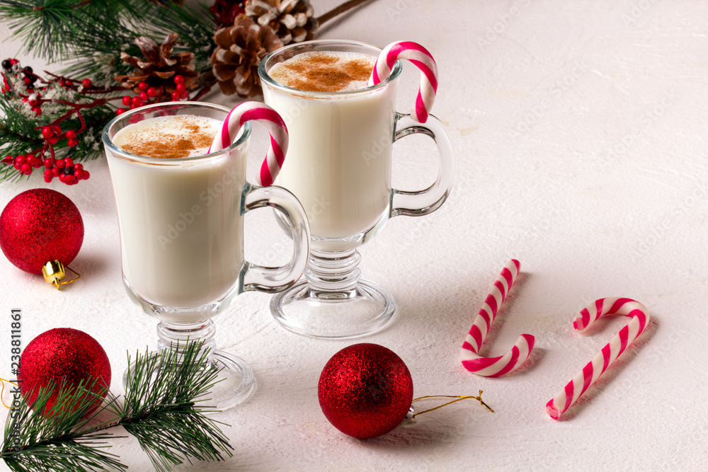 Christmas eggnog in glass mug and cinnamon. Christmas eggnog in glass mug and cinnamon.