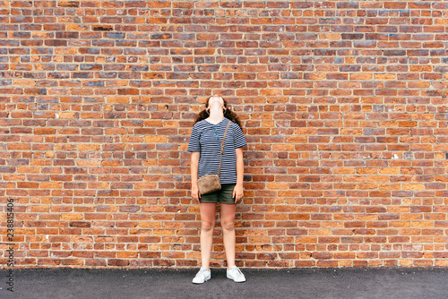 Photography Girl looking up against brick wall background
