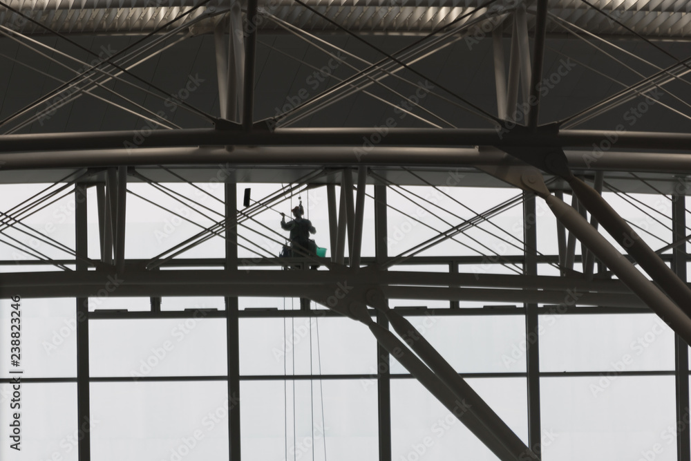 Window Cleaner with green bucket seen from inside building Window Cleaner with green bucket seen from inside building