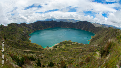 Panoramic view of the emerald green lagoon inside the crater of the Quilotoa volcano. Quilotoa is a water-filled caldera and the most western volcano in the Ecuadorian Andes.